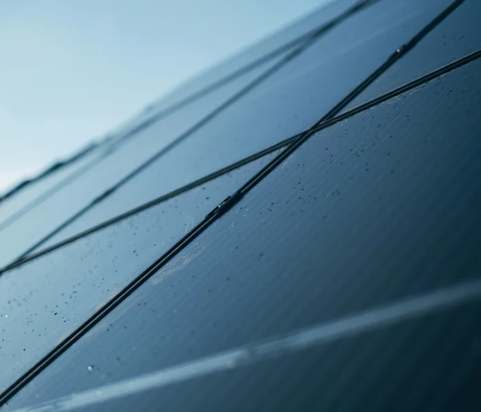 Gros plan d’un panneau solaire incliné sous un ciel bleu.
